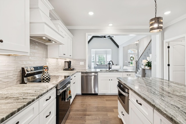 1037 Jackston Mack Way, Gallatin, TN 37066 - kitchen with stainless steel appliances, custom range hood, ceiling fan, white cabinets, and ornamental molding