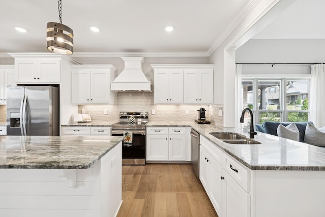 1037 Jackston Mack Way, Gallatin, TN 37066 - kitchen with appliances with stainless steel finishes, custom exhaust hood, white cabinets, a peninsula, and crown molding