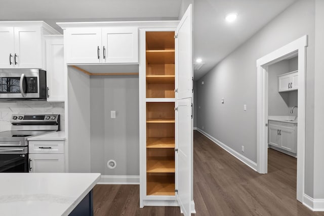 108 Hummingbird Way, Clarksville, TN 37043 - kitchen with appliances with stainless steel finishes, dark wood-type flooring, white cabinetry, and recessed lighting