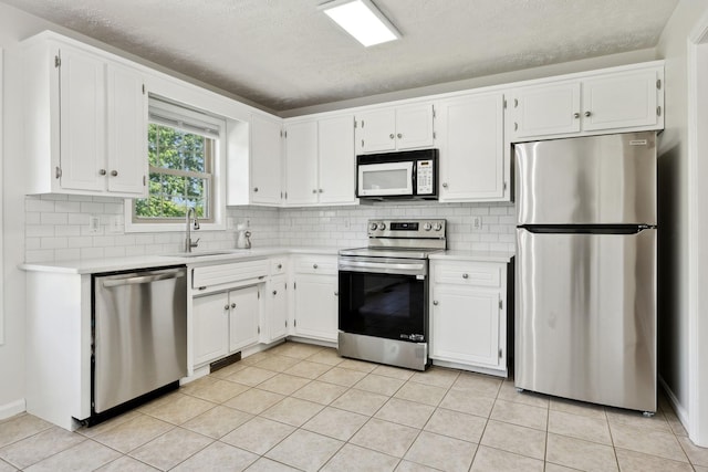 853 Hornbuckle Rd, Clarksville, TN 37043 - kitchen featuring appliances with stainless steel finishes, light countertops, tasteful backsplash, white cabinets, and a textured ceiling