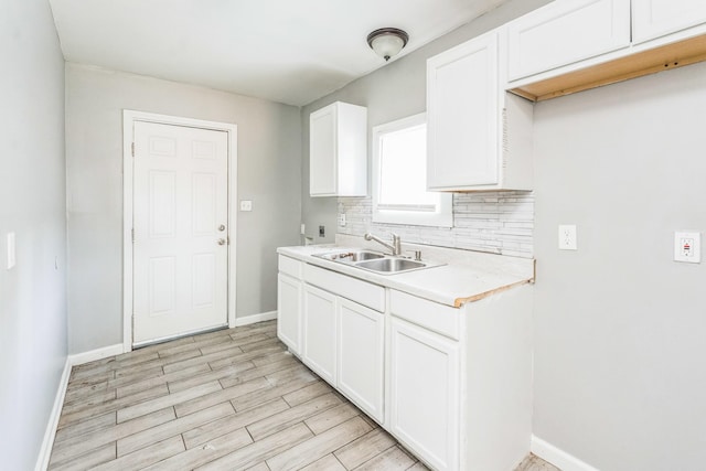 2191 Clayton Ave, Memphis, TN 38108 - kitchen featuring tasteful backsplash, light countertops, light wood-type flooring, and white cabinets