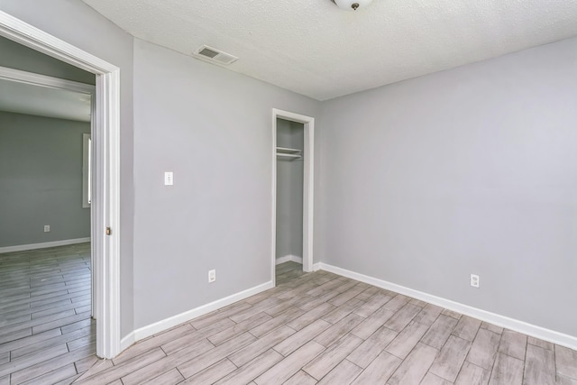 2191 Clayton Ave, Memphis, TN 38108 - unfurnished bedroom featuring light wood-type flooring, a closet, and a textured ceiling