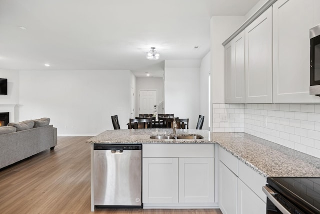 3276 Holiday Ln, Columbia, TN 38401 - kitchen with stainless steel appliances, a peninsula, backsplash, open floor plan, and light wood-style flooring