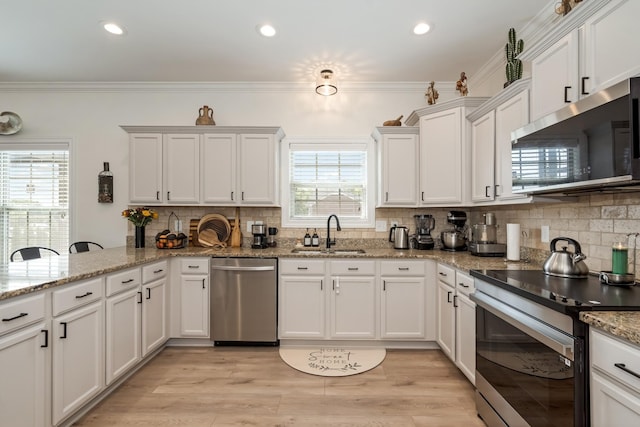 2018 Via Francesco Ct, Spring Hill, TN 37174 - kitchen featuring stainless steel appliances, tasteful backsplash, white cabinetry, ornamental molding, and light wood-type flooring
