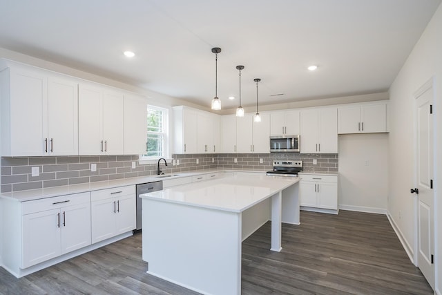 4018 Rampart Way, Spring Hill, TN 37174 - kitchen with appliances with stainless steel finishes, white cabinetry, dark wood-style floors, a kitchen island, and recessed lighting