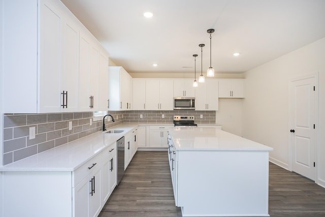 4018 Rampart Way, Spring Hill, TN 37174 - kitchen with appliances with stainless steel finishes, a kitchen island, decorative backsplash, dark wood-style floors, and white cabinets