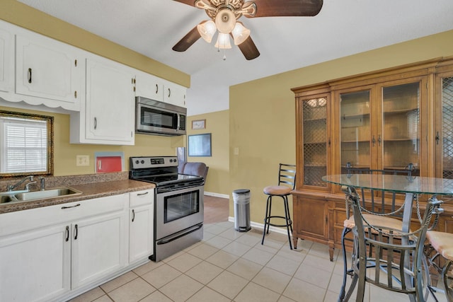 575 Cynthia Dr, Clarksville, TN 37042 - kitchen featuring appliances with stainless steel finishes, ceiling fan, light tile patterned flooring, white cabinets, and glass insert cabinets