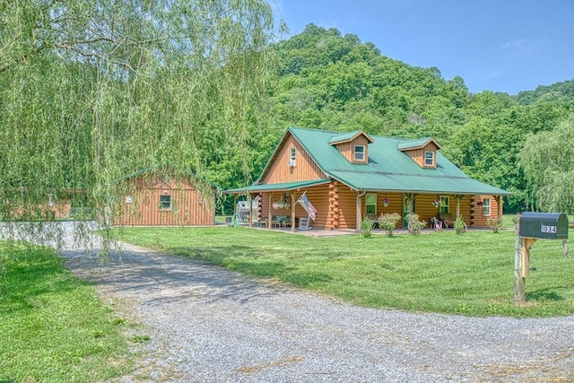 1034 Gaw Branch Rd, Gainesboro, TN 38562 - cabin with driveway, log siding, a porch, a forest view, and a front lawn