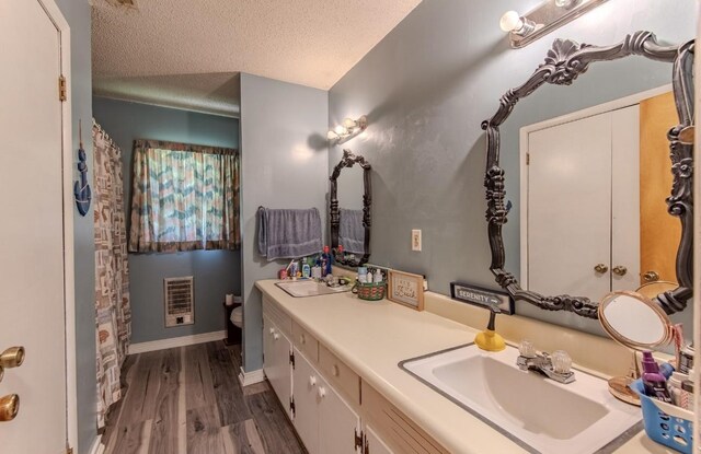 5011 Sunny Acres Dr, Waynesboro, TN 38485 - bathroom featuring wood finished floors, vanity, heating unit, and a textured ceiling