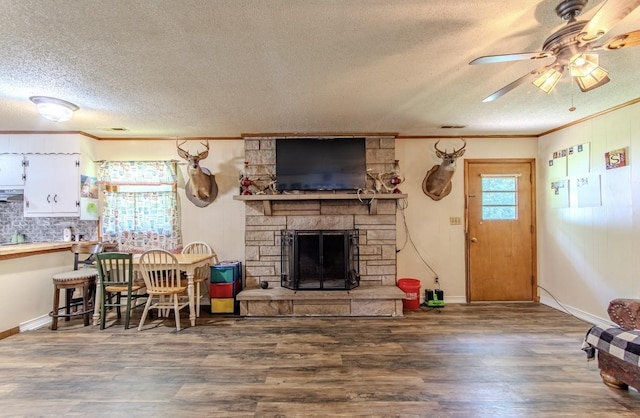 5011 Sunny Acres Dr, Waynesboro, TN 38485 - living area featuring crown molding, a textured ceiling, a stone fireplace, wood finished floors, and ceiling fan