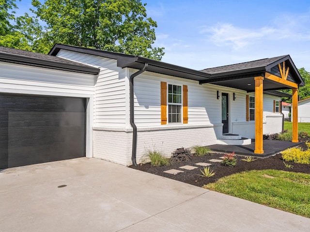 227 Shady Grove Rd, Manchester, TN 37355 - view of front of property with brick siding, driveway, covered porch, an attached garage, and a shingled roof