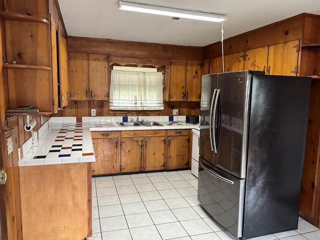 902 Mcarthur St, Manchester, TN 37355 - kitchen featuring freestanding refrigerator, tile countertops, brown cabinets, light tile patterned flooring, and open shelves