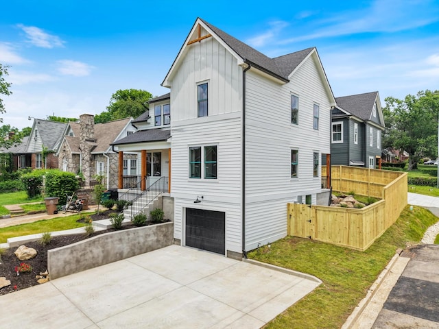 1135 Delmas Ave, Nashville, TN 37216 - view of front of home with board and batten siding, an attached garage, driveway, a residential view, and a shingled roof