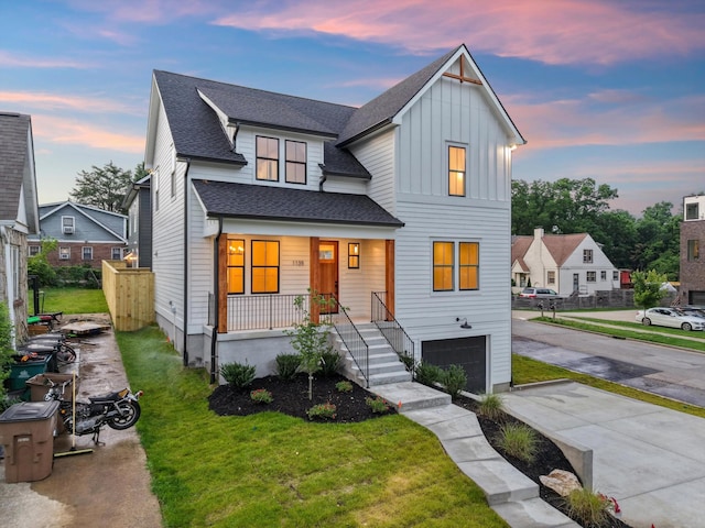 1135 Delmas Ave, Nashville, TN 37216 - view of front of house featuring a garage, covered porch, board and batten siding, a yard, and roof with shingles