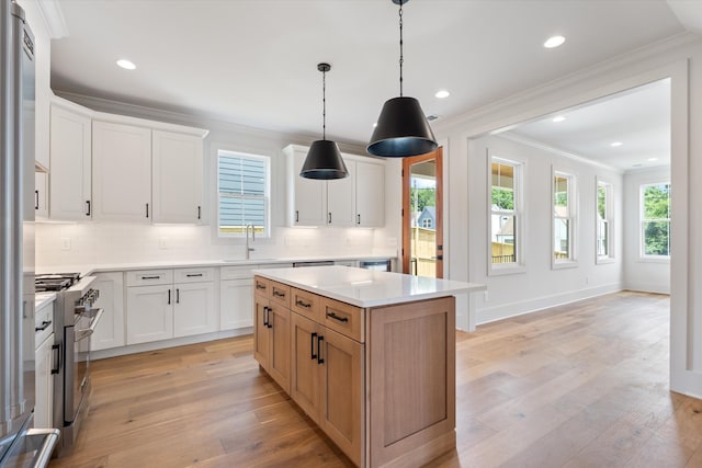 1135 Delmas Ave, Nashville, TN 37216 - kitchen with stainless steel range, ornamental molding, backsplash, light countertops, and a center island