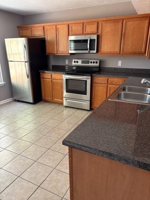 348 Arapaho Dr, Murfreesboro, TN 37128 - kitchen featuring appliances with stainless steel finishes, light tile patterned floors, and brown cabinets