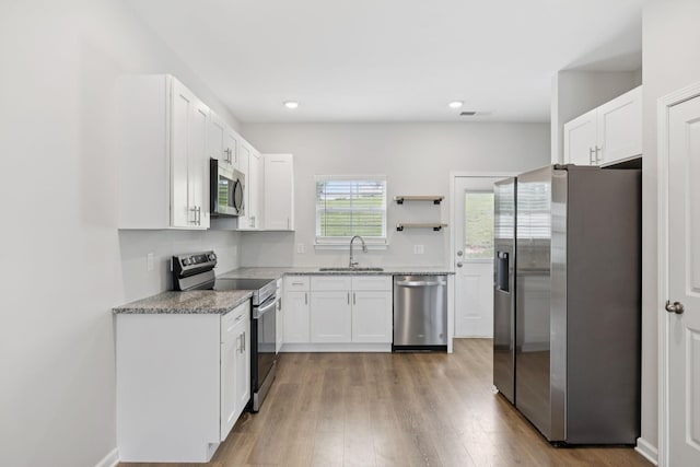 344 Kristen Ct, Columbia, TN 38401 - kitchen featuring stainless steel appliances, white cabinets, light wood finished floors, light stone counters, and recessed lighting