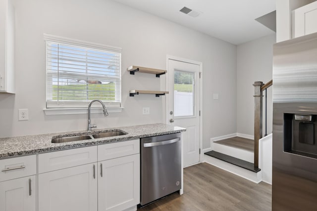 344 Kristen Ct, Columbia, TN 38401 - kitchen with stainless steel appliances, white cabinetry, light wood-style flooring, and light stone countertops