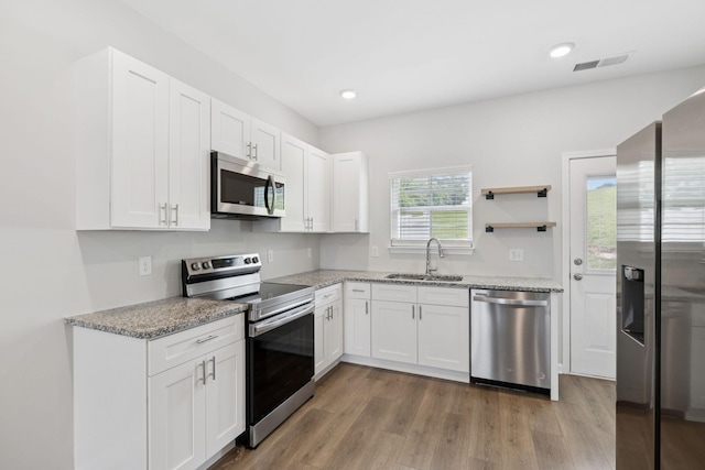 344 Kristen Ct, Columbia, TN 38401 - kitchen featuring appliances with stainless steel finishes, light wood-style floors, white cabinets, light stone counters, and recessed lighting