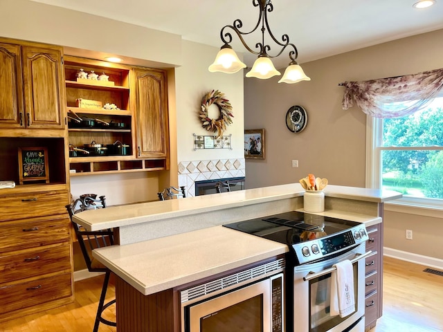2214 Henpeck Ln, Franklin, TN 37064 - kitchen featuring appliances with stainless steel finishes, light wood finished floors, brown cabinetry, light countertops, and recessed lighting