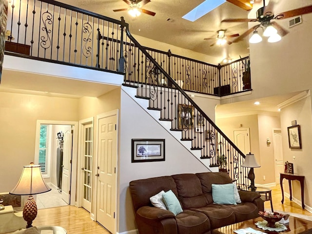 2214 Henpeck Ln, Franklin, TN 37064 - living room with a ceiling fan, stairway, a high ceiling, wood finished floors, and a skylight