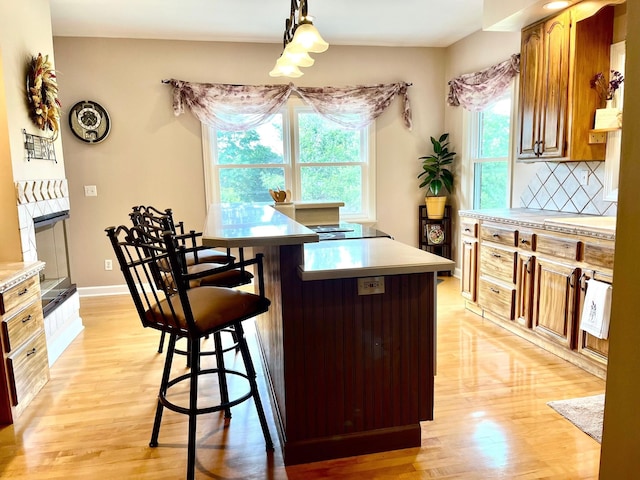 2214 Henpeck Ln, Franklin, TN 37064 - kitchen with a kitchen breakfast bar, light wood finished floors, light countertops, and brown cabinetry