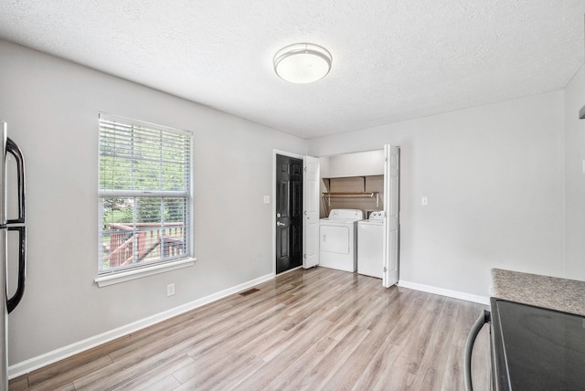 643 Artic Ave, Oak Grove, KY 42262 - unfurnished living room with washer and dryer, light wood-style floors, and a textured ceiling