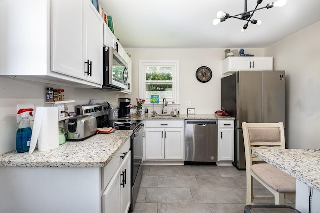 100 Beech St, Columbia, TN 38401 - kitchen featuring stainless steel appliances, white cabinetry, a chandelier, and light stone counters