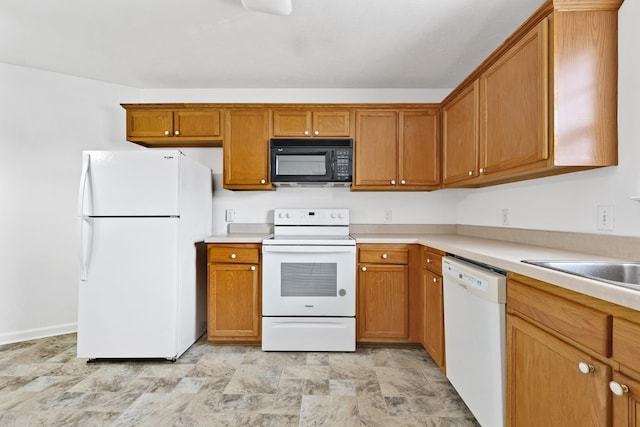 912 Patty Cv, La Vergne, TN 37086 - kitchen with white appliances, stone finish flooring, light countertops, and brown cabinets