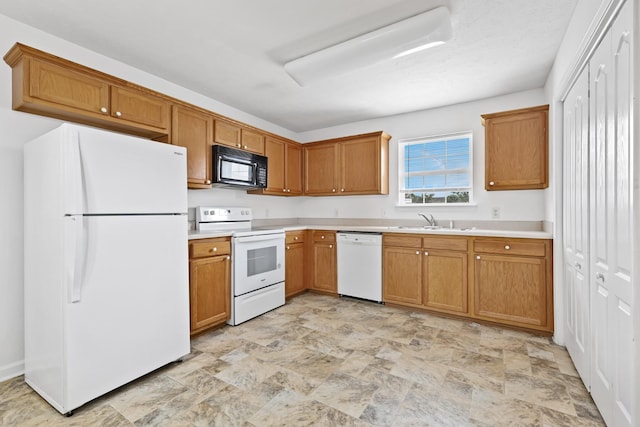 912 Patty Cv, La Vergne, TN 37086 - kitchen with white appliances, stone finish flooring, light countertops, and brown cabinets