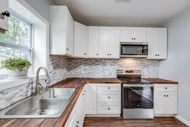 1689 Sumac Rd, Pulaski, TN 38478 - kitchen featuring wooden counters, appliances with stainless steel finishes, tasteful backsplash, dark wood finished floors, and white cabinetry