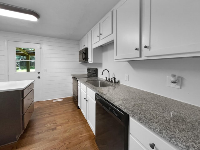 7120 Sutton Pl, Fairview, TN 37062 - kitchen featuring black appliances, dark wood-style floors, white cabinets, and wooden walls