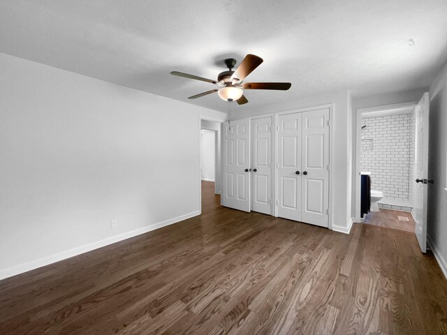 7120 Sutton Pl, Fairview, TN 37062 - unfurnished bedroom featuring multiple closets, dark wood-style flooring, ensuite bathroom, and ceiling fan