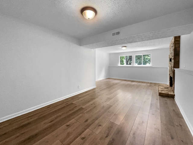 7120 Sutton Pl, Fairview, TN 37062 - unfurnished living room with a textured ceiling, wood finished floors, and a fireplace