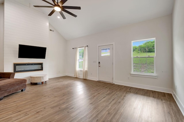 94 Hickory Ridge Ln, Woodbury, TN 37190 - unfurnished living room featuring ceiling fan, wood finished floors, high vaulted ceiling, and a glass covered fireplace