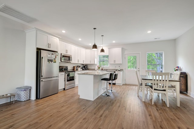 94 Hickory Ridge Ln, Woodbury, TN 37190 - kitchen featuring appliances with stainless steel finishes, plenty of natural light, white cabinets, a breakfast bar area, and recessed lighting