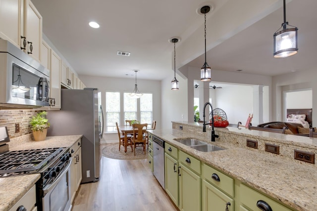309 Patriotic Way, Mount Juliet, TN 37122 - kitchen with stainless steel appliances, green cabinetry, light wood-style flooring, tasteful backsplash, and decorative light fixtures