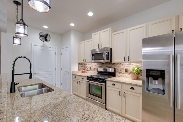 309 Patriotic Way, Mount Juliet, TN 37122 - kitchen with appliances with stainless steel finishes, decorative backsplash, light stone countertops, pendant lighting, and recessed lighting