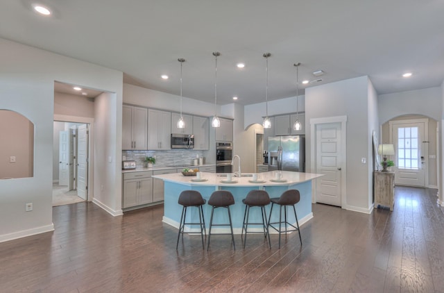 1655 Burrows Ave, Murfreesboro, TN 37129 - kitchen with stainless steel appliances, arched walkways, dark wood-type flooring, an island with sink, and recessed lighting