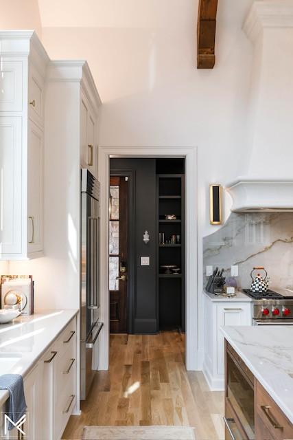 119 Winslow Rd, Franklin, TN 37064 - kitchen featuring high quality appliances, light wood-style floors, white cabinetry, custom exhaust hood, and light stone countertops