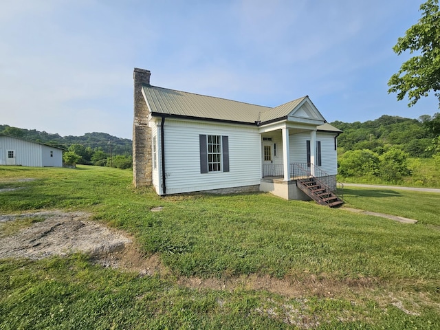 2740 Gladdice Hwy, Whitleyville, TN 38588 - view of front of home featuring a chimney, covered porch, a front lawn, and a metal roof