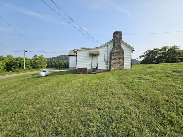 2740 Gladdice Hwy, Whitleyville, TN 38588 - back of property featuring a chimney, a yard, and entry steps