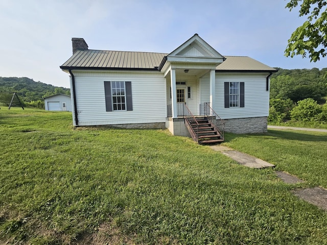 2740 Gladdice Hwy, Whitleyville, TN 38588 - view of front facade with a chimney, a front yard, a metal roof, and a detached garage
