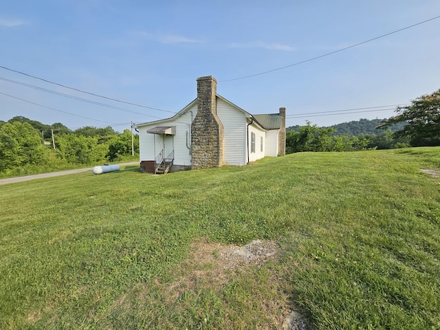 2740 Gladdice Hwy, Whitleyville, TN 38588 - view of side of home featuring a chimney, a yard, and entry steps