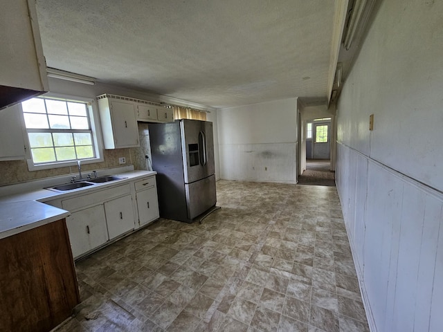 2740 Gladdice Hwy, Whitleyville, TN 38588 - kitchen featuring stainless steel fridge with ice dispenser, plenty of natural light, light countertops, white cabinetry, and a textured ceiling
