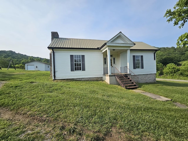 2740 Gladdice Hwy, Whitleyville, TN 38588 - view of front facade with a chimney, a metal roof, a front lawn, and a garage
