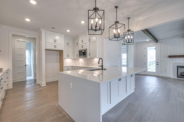 4013 Singing Creek Dr, Franklin, TN 37064 - kitchen with stainless steel microwave, a chandelier, white cabinetry, light wood-type flooring, and recessed lighting