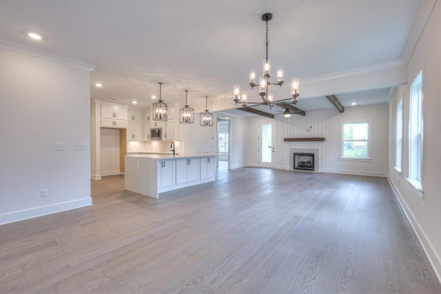4013 Singing Creek Dr, Franklin, TN 37064 - unfurnished living room with a chandelier, light wood-type flooring, recessed lighting, a fireplace, and crown molding