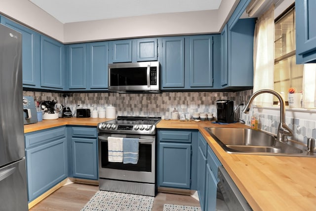 259 Mayflower Ln N, Madison, TN 37115 - kitchen with stainless steel appliances, wood counters, and blue cabinetry