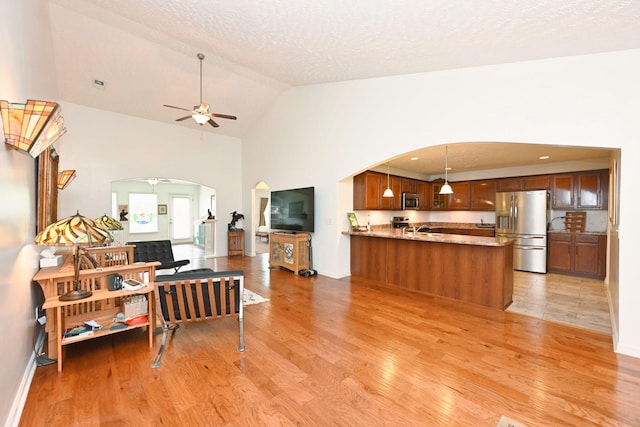 395 Devon Chase Hl Unit 3602, Gallatin, TN 37066 - living area featuring arched walkways, light wood-type flooring, ceiling fan, high vaulted ceiling, and a textured ceiling